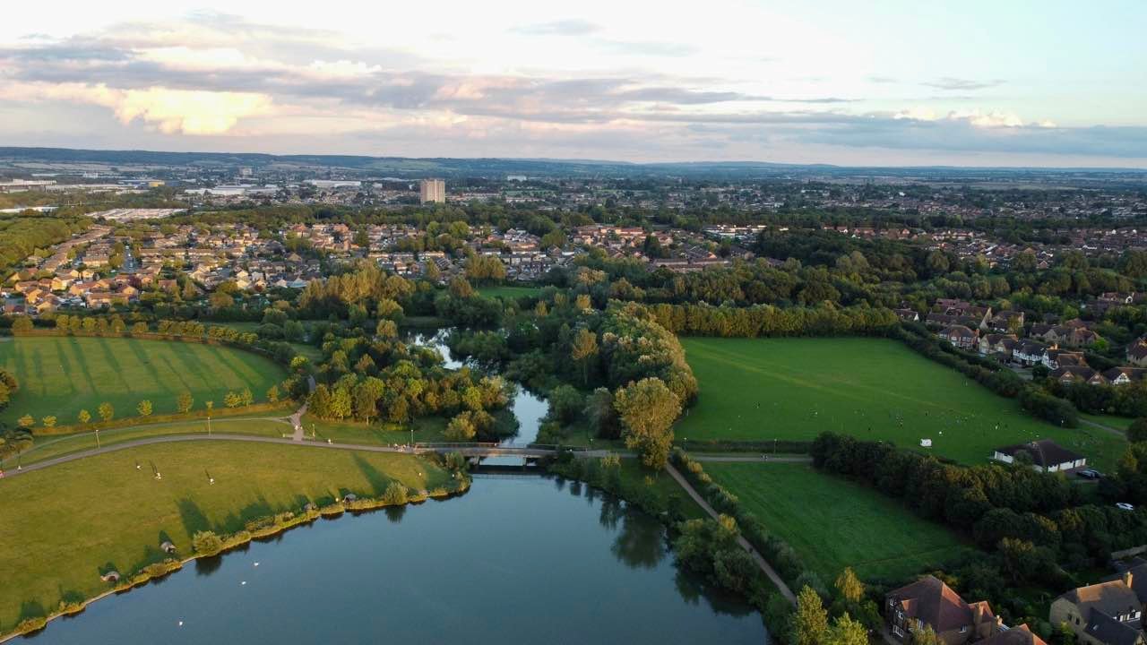 Aerial view of Furzton Lake in Milton Keynes, surrounded by trees, fields and housing